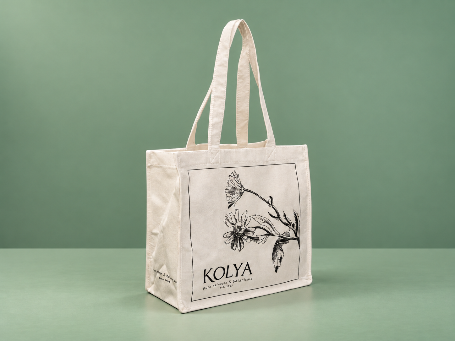 Bamboo shopping bag with floral KOLYA print on a sage-green studio background